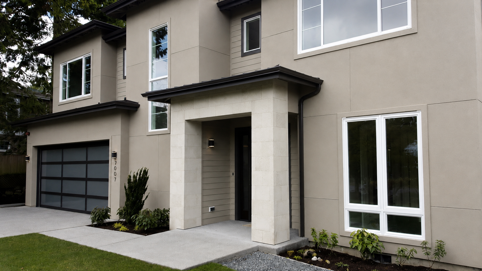 Stucco home entry with columns and balcony